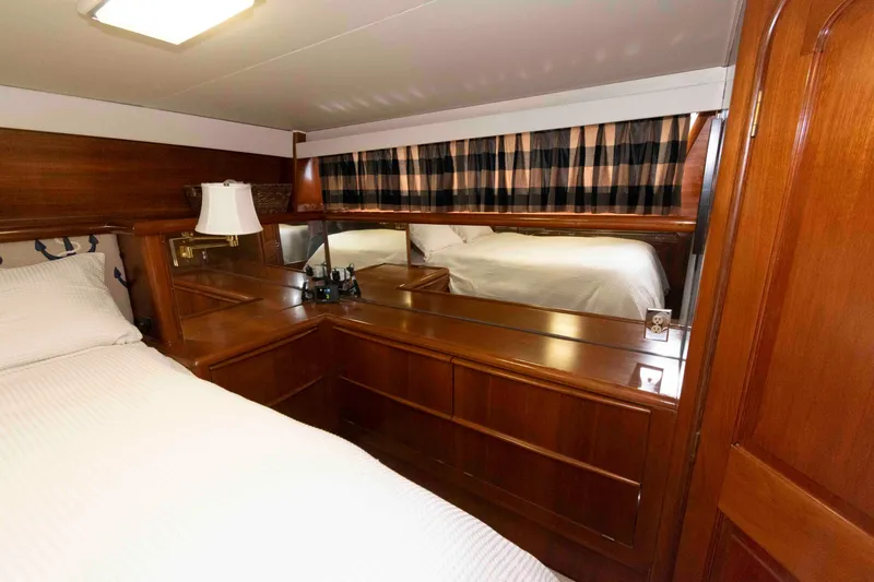 Slide: The Image of Luxurious 1990 Viking 50 Motor Yacht cabin with elegant wood finish and cozy bedding. - 26