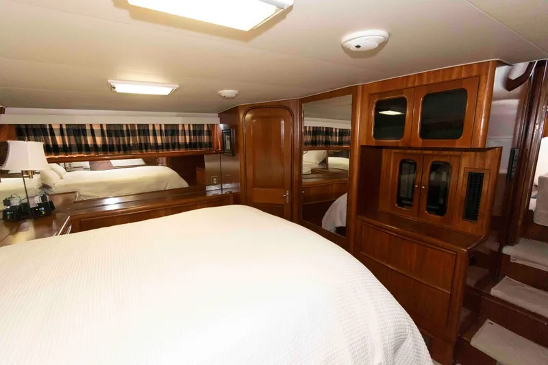 Slide: The Image of Luxurious 1990 Viking 50 Motor Yacht bedroom with wood cabinetry and cozy bedding. - 27