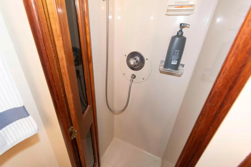 Slide: The Image of Shower area in 1990 Viking 50 Motor Yacht with wooden door and soap dispenser. - 30