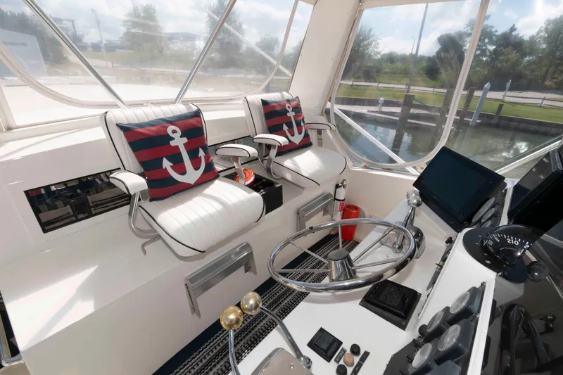 Slide: The Image of Helm of 1990 Viking 50 Motor Yacht with anchor-themed cushions and navigational equipment. - 8