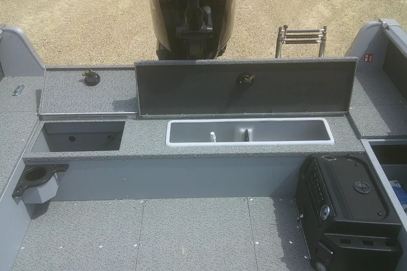 Slide: The Image of 2026 Lund 1800 Explorer Tiller boat interior with storage compartments and motor. - 11