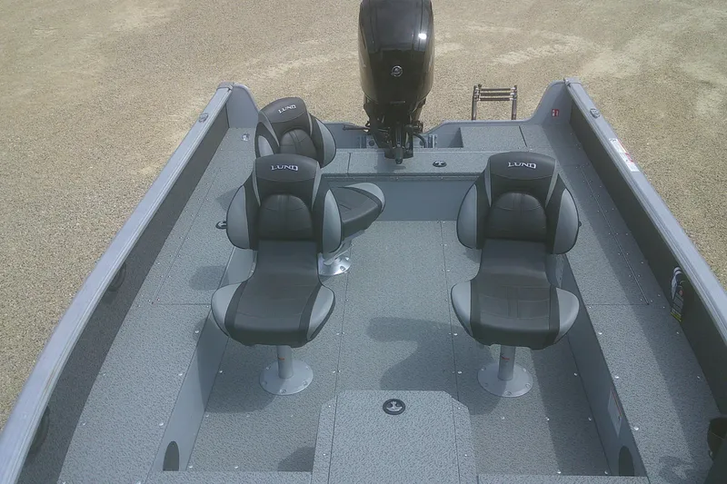 Slide: The Image of 2026 Lund 1800 Explorer Tiller boat interior with three seats and motor. - 6