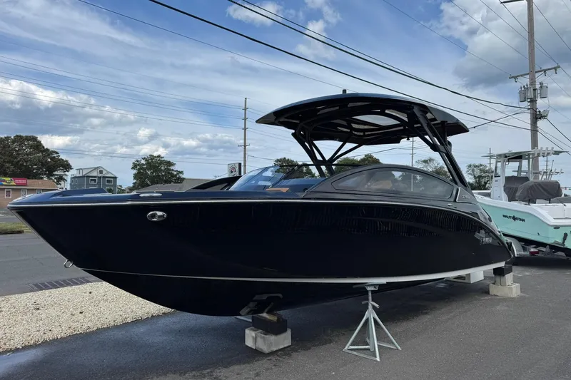 The Image of 2026 Yamaha Boats 275SD displayed outdoors on a stand under a cloudy sky. - 0