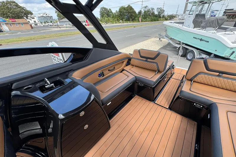 Slide: The Image of 2026 Yamaha Boats 275SD interior with tan seating and wood flooring. - 15