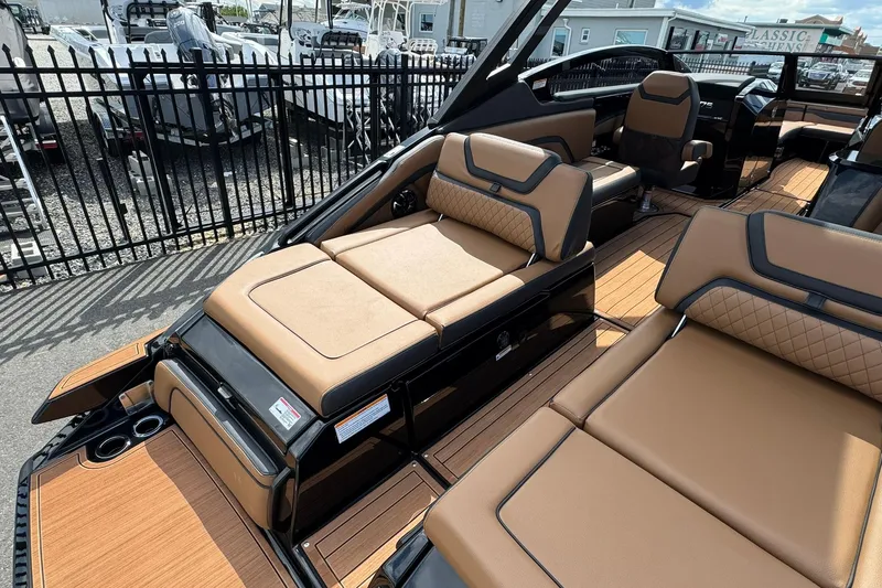 Slide: The Image of 2026 Yamaha Boats 275SD with luxurious tan seating, displayed near a boat sales sign. - 19