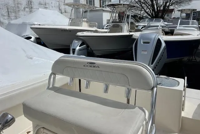 Slide: The Image of 2020 Cobia 237 Center Console boat in marina with other vessels. - 14