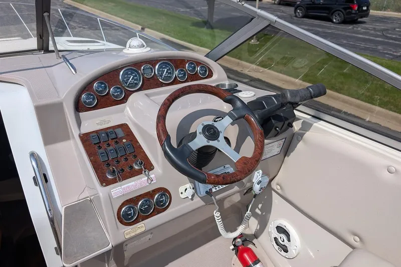 Slide: The Image of 2001 Regal Commodore 2660 boat dashboard with wood-trimmed steering wheel and instrument panel. - 19
