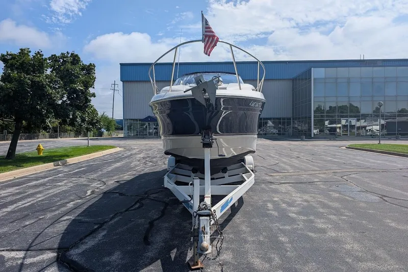 Slide: The Image of 2001 Regal Commodore 2660 boat on trailer, parked in front of a modern building. - 3