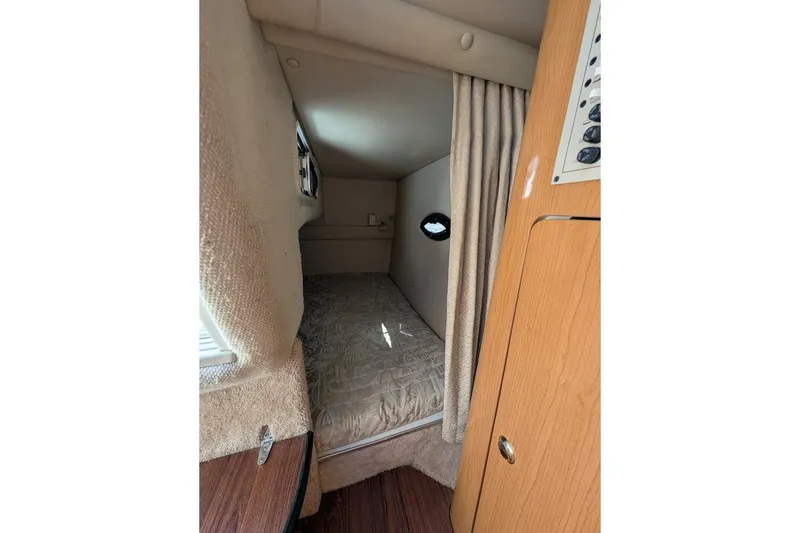Slide: The Image of 2001 Regal Commodore 2660 cabin interior with cozy sleeping area and wooden accents. - 32
