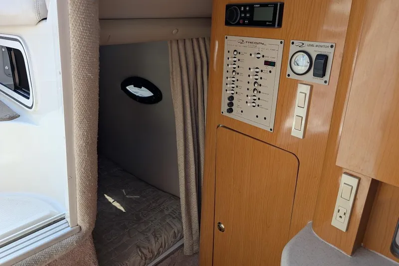 Slide: The Image of 2001 Regal Commodore 2660 cabin interior with control panel and sleeping area. - 33