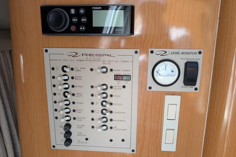 Slide: The Image of Control panel of a 2001 Regal Commodore 2660 boat with switches and level monitor. - 34