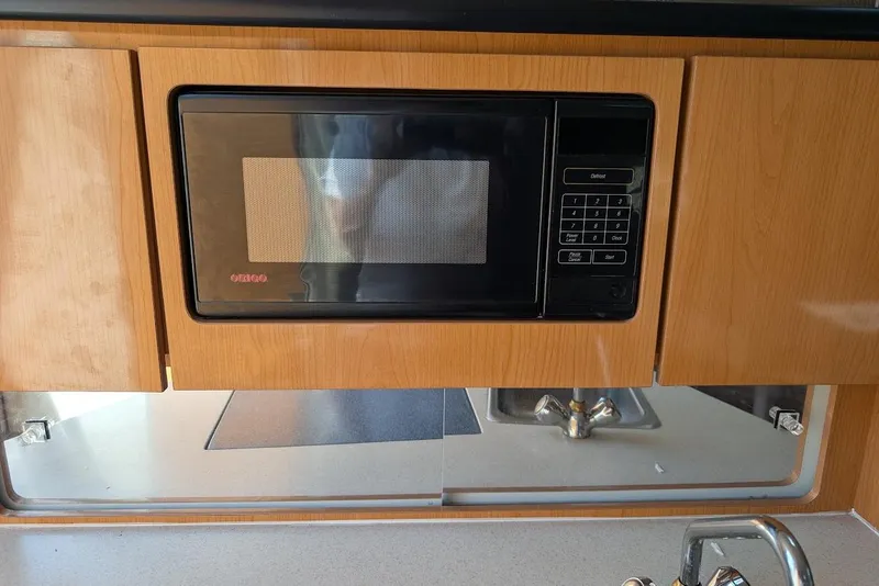 Slide: The Image of Microwave in 2001 Regal Commodore 2660 boat kitchen with wooden cabinetry. - 37
