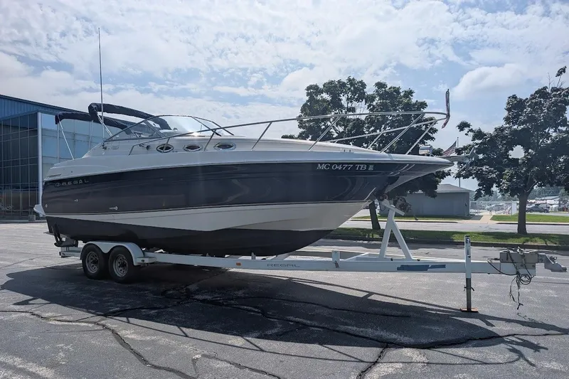 Slide: The Image of 2001 Regal Commodore 2660 boat on trailer, parked outdoors under a partly cloudy sky. - 4