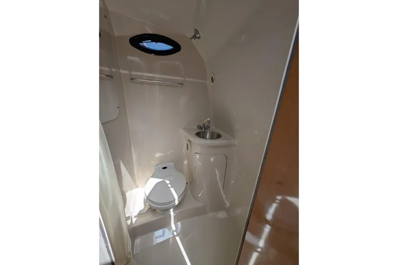 Slide: The Image of 2001 Regal Commodore 2660 boat bathroom with toilet, sink, and porthole window. - 42