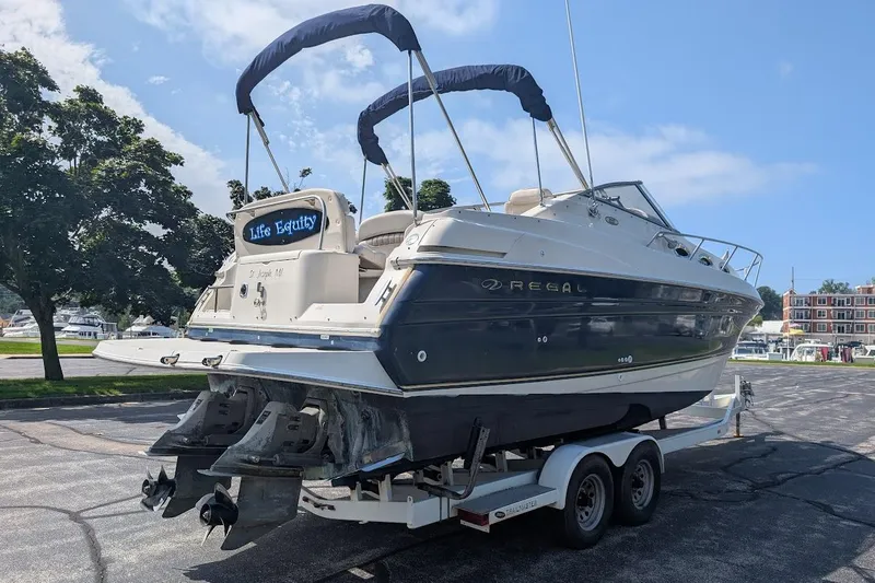 Slide: The Image of 2001 Regal Commodore 2660 boat on trailer, parked outdoors under clear sky. - 6