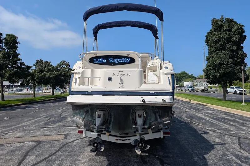 Slide: The Image of 2001 Regal Commodore 2660 boat parked on a street, rear view with blue canopy. - 7