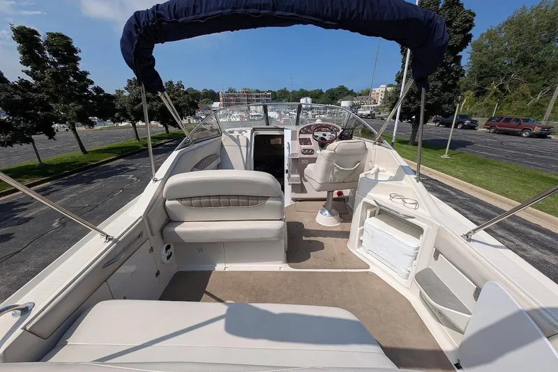 Slide: The Image of 2001 Regal Commodore 2660 boat interior with seating and helm, parked near trees. - 9