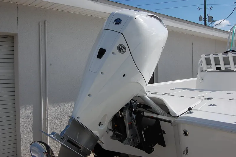 Slide: The Image of 2026 Cape Horn 23 Cape Bay boat with a powerful outboard motor, docked near a building. - 3