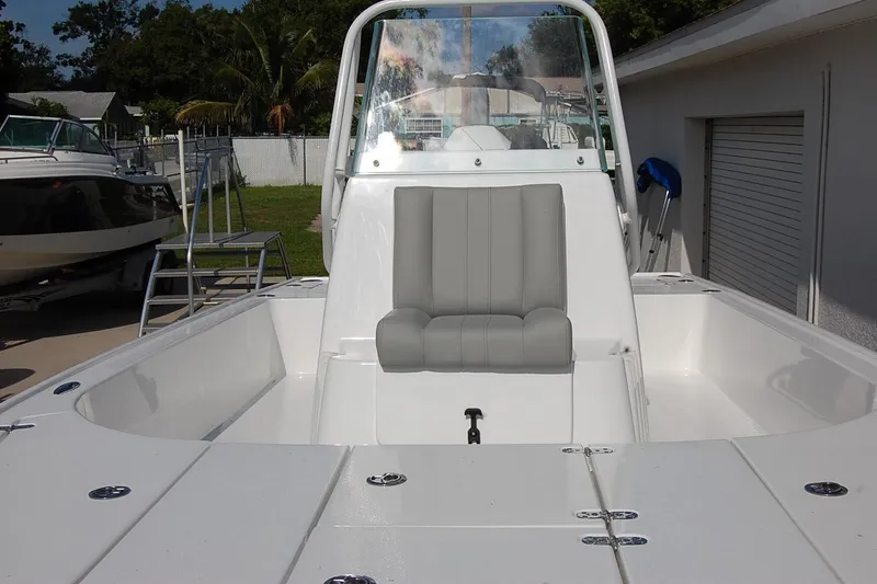 Slide: The Image of 2026 Cape Horn 23 Cape Bay boat interior with seating and console, docked outdoors. - 21