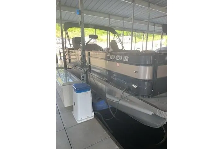 Slide: The Image of 2023 PlayCraft 27 Infinity pontoon boat docked under a covered marina. - 9