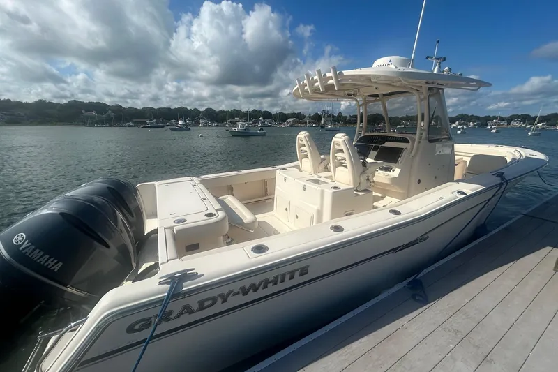 Slide: The Image of 2017 Grady-White Canyon 306 boat docked, featuring Yamaha engines, under a clear sky. - 0