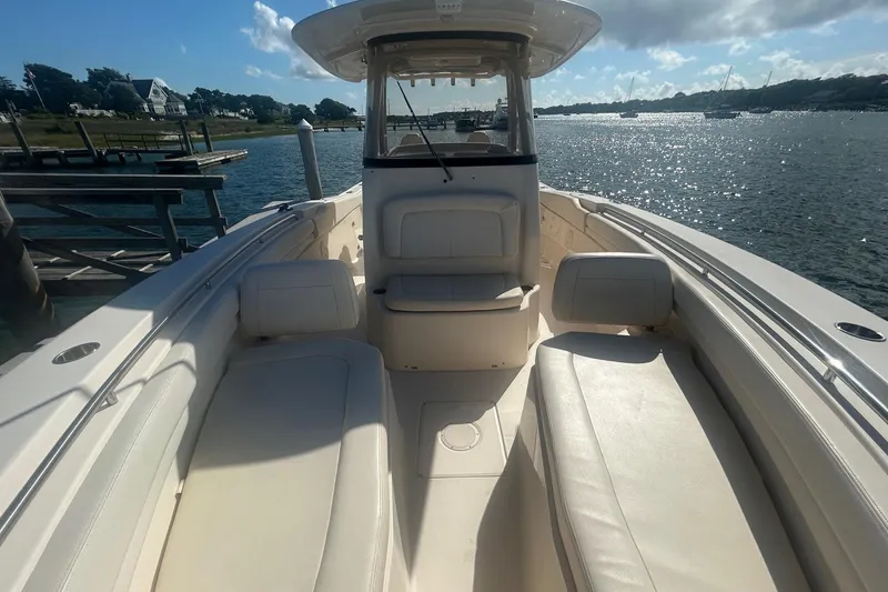 Slide: The Image of 2017 Grady-White Canyon 306 boat interior with seating, docked by a scenic waterfront. - 10