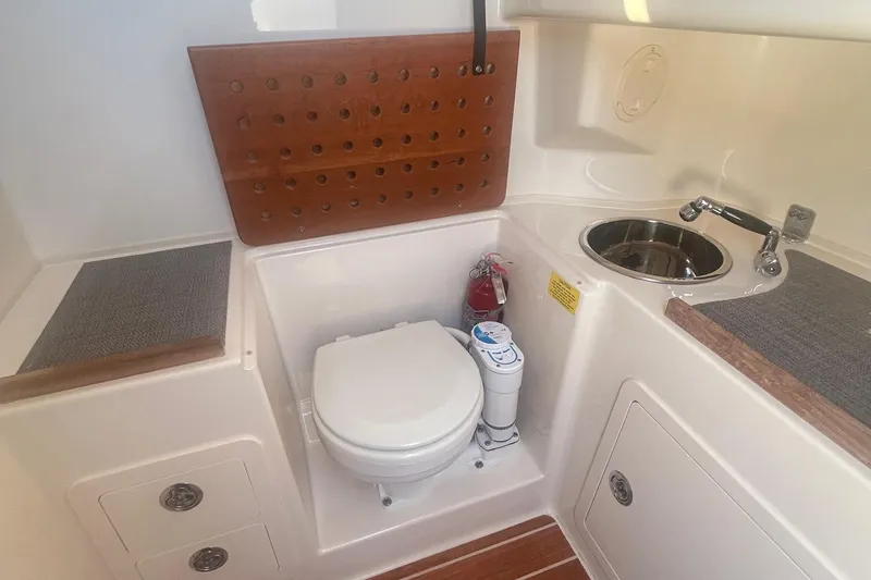Slide: The Image of 2017 Grady-White Canyon 306 boat bathroom with toilet, sink, and fire extinguisher. - 14
