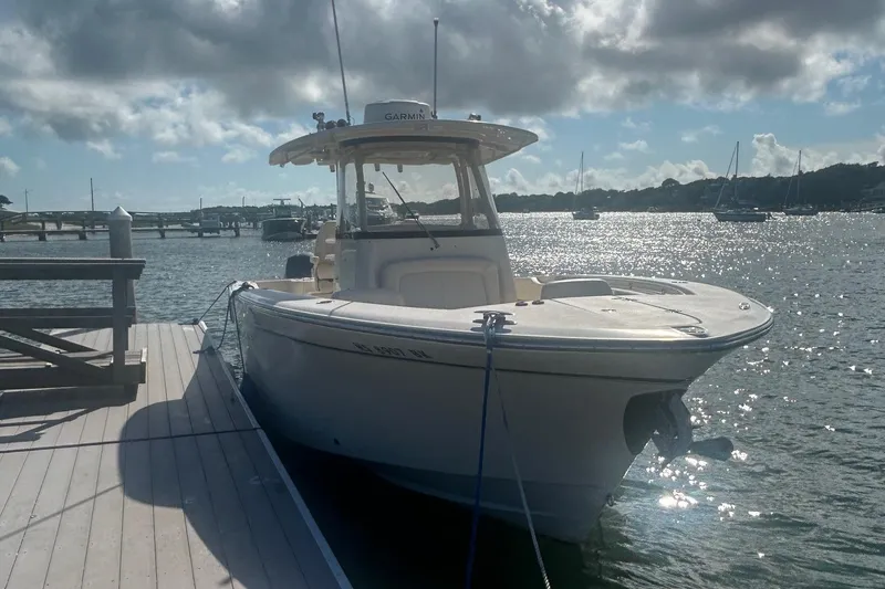 Slide: The Image of 2017 Grady-White Canyon 306 boat docked on a sunny day by the water. - 2