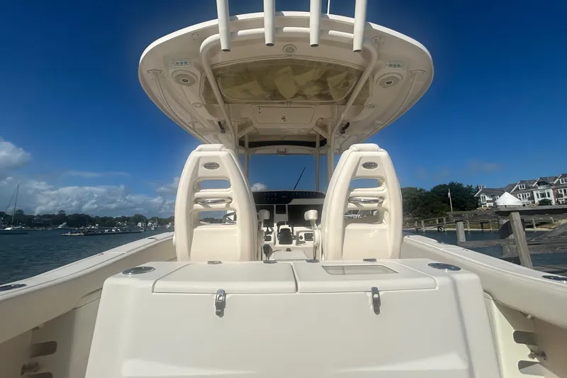 Slide: The Image of 2017 Grady-White Canyon 306 boat interior with helm, docked by waterfront homes. - 4