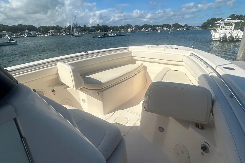 Slide: The Image of 2017 Grady-White Canyon 306 boat interior with seating, docked in a scenic harbor. - 8