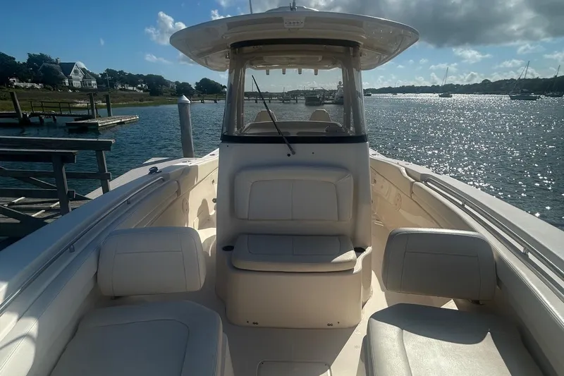 Slide: The Image of 2017 Grady-White Canyon 306 boat on a sunny waterfront, showcasing seating and helm. - 9