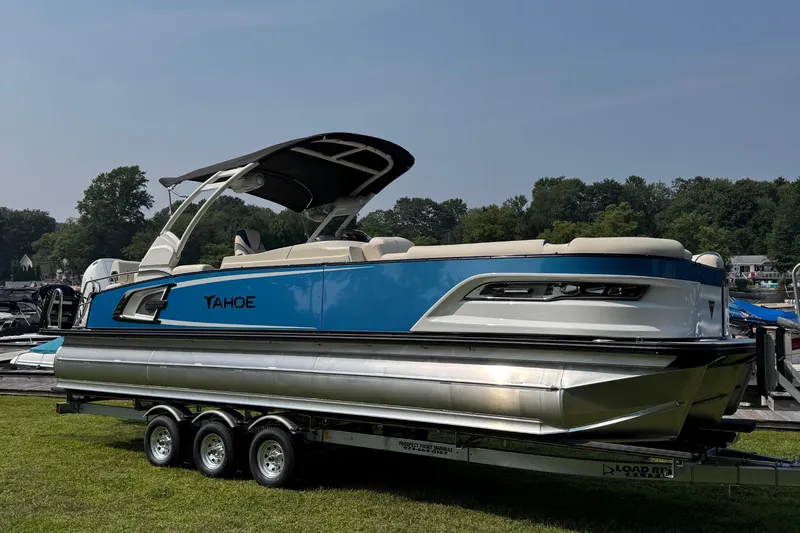 The Image of 2026 Tahoe Pontoon Grand Tahoe LTD Quad Lounge on trailer, blue and white design. - 0