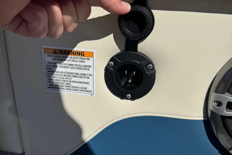 Slide: The Image of 2026 Tahoe Pontoon Grand Tahoe LTD Quad Lounge power outlet with safety warning label. - 15