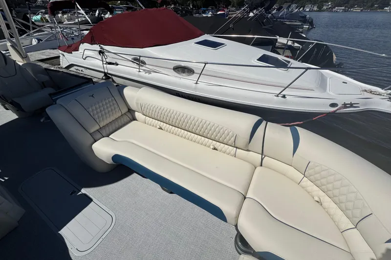 Slide: The Image of 2026 Tahoe Pontoon Grand Tahoe LTD Quad Lounge with luxurious seating at a marina. - 6