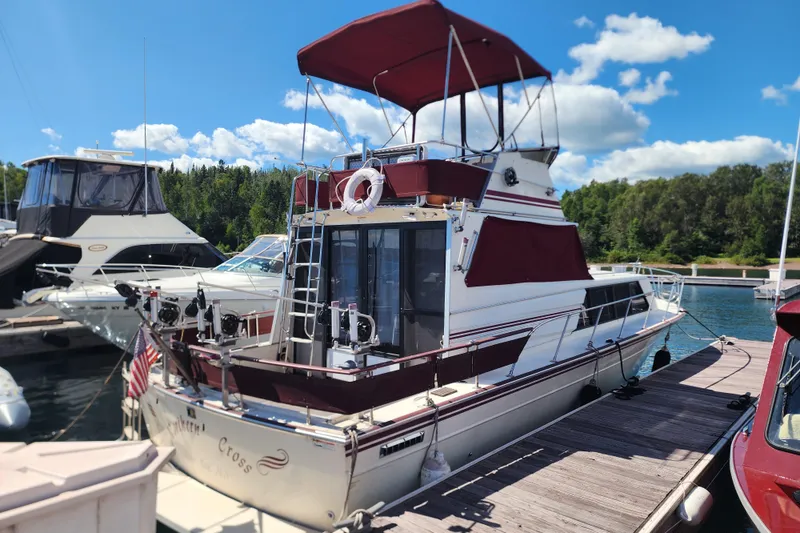 The Image of 1989 Marinette 32 Sedan Flybridge docked at marina under clear blue sky. - 1