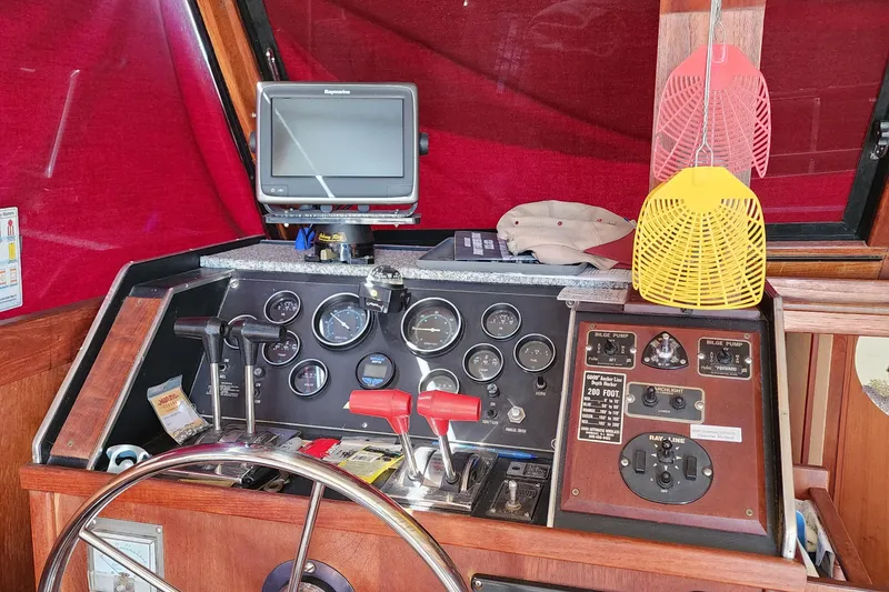 Slide: The Image of 1989 Marinette 32 Sedan Flybridge helm with gauges, controls, and fly swatters. - 14