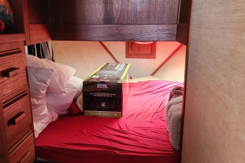 Slide: The Image of Cozy cabin interior of 1989 Marinette 32 Sedan Flybridge with red bedding and wooden accents. - 17