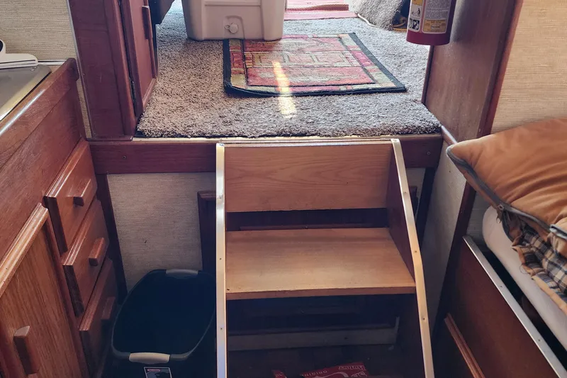 Slide: The Image of Interior of 1989 Marinette 32 Sedan Flybridge with wooden steps and carpeted flooring. - 21