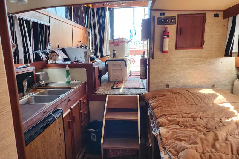 Slide: The Image of Interior of 1989 Marinette 32 Sedan Flybridge with kitchen, bed, and seating area. - 22