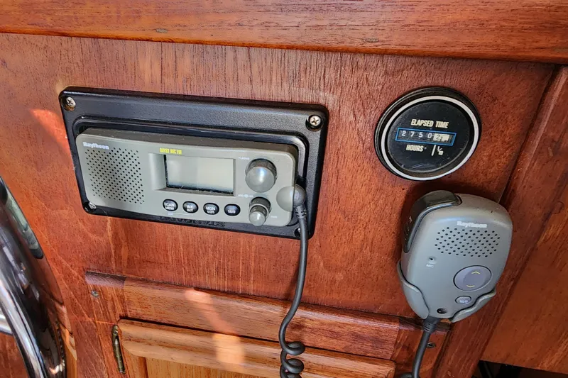 Slide: The Image of 1989 Marinette 32 Sedan Flybridge radio and elapsed time gauge on wooden dashboard. - 24