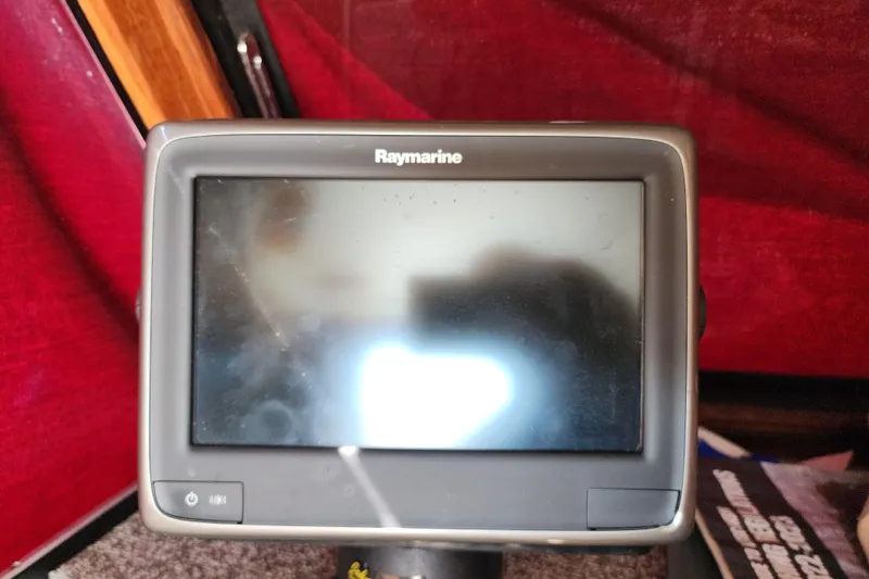 Slide: The Image of Raymarine display on 1989 Marinette 32 Sedan Flybridge boat, red interior background. - 28