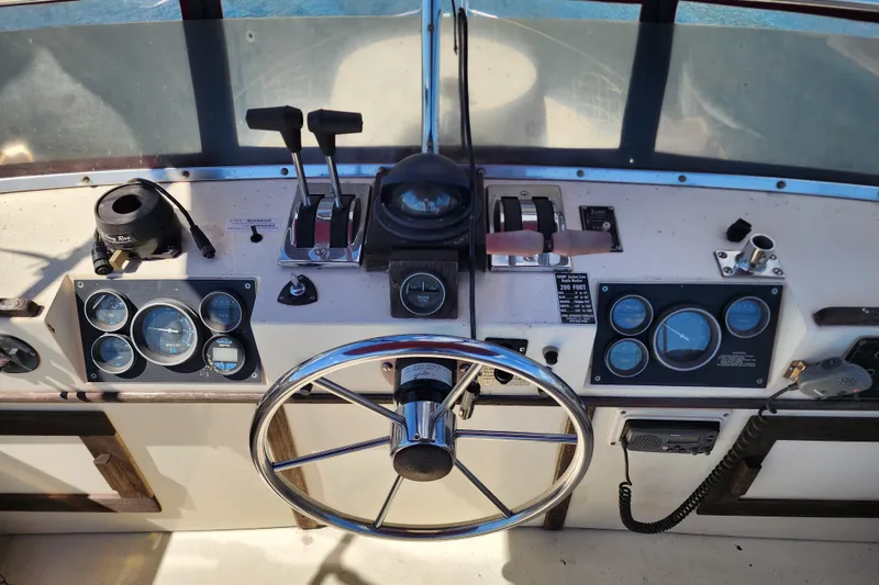 Slide: The Image of 1989 Marinette 32 Sedan Flybridge helm with steering wheel, gauges, and controls. - 30
