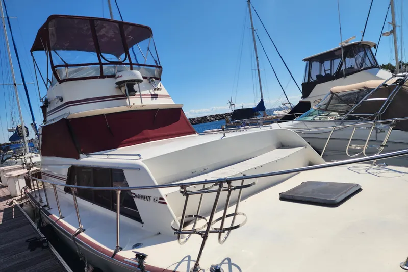Slide: The Image of 1989 Marinette 32 Sedan Flybridge docked at marina under clear blue sky. - 5
