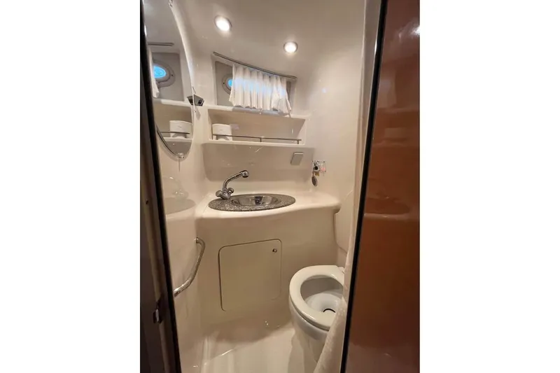 Slide: The Image of 2009 Chaparral Signature 280 boat bathroom with sink, toilet, and storage shelves. - 10