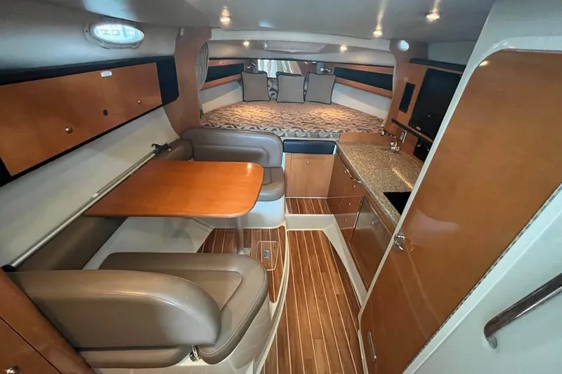 Slide: The Image of 2009 Chaparral Signature 280 interior with wood accents, dining area, and cozy sleeping space. - 8