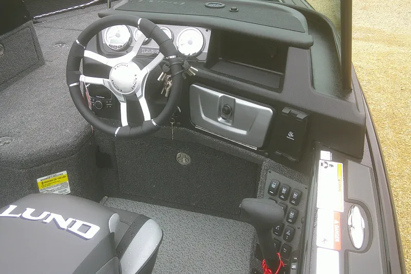 Slide: The Image of 2025 Lund 1875 Pro-V boat cockpit with steering wheel and control panel. - 10