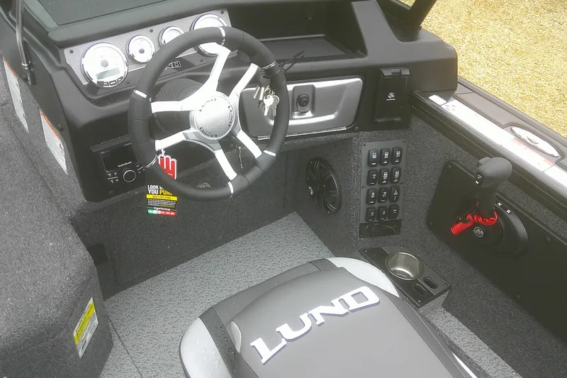 Slide: The Image of 2025 Lund 1875 Pro-V boat cockpit with steering wheel, controls, and dashboard instruments. - 11