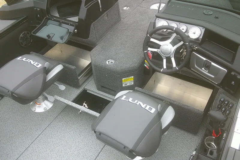Slide: The Image of 2025 Lund 1875 Pro-V boat interior with steering wheel, storage compartments, and branded seats. - 13