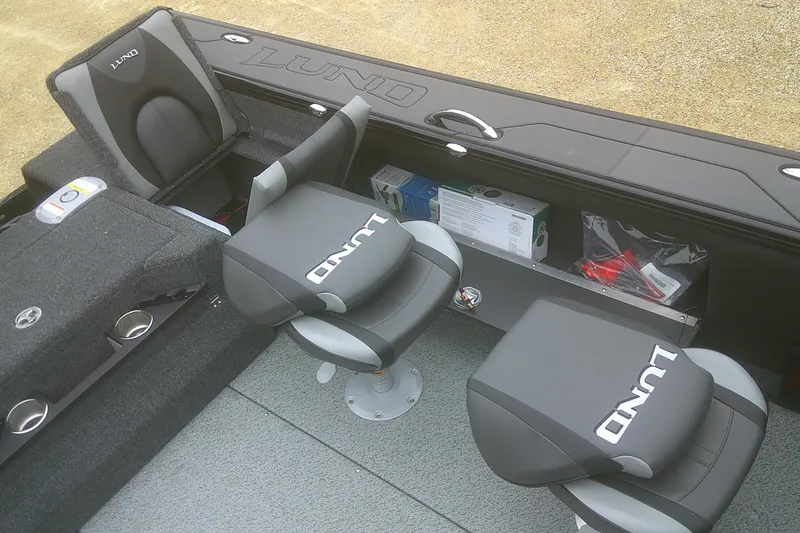 Slide: The Image of 2025 Lund 1875 Pro-V boat interior with branded seats and storage compartments. - 16