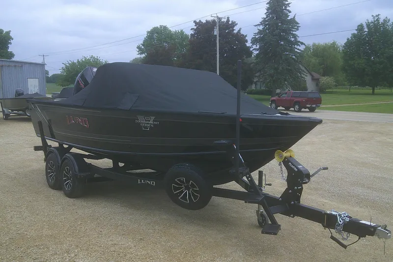 Slide: The Image of 2025 Lund 1875 Pro-V boat on trailer, covered, parked outdoors. - 19